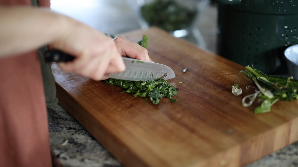 woman hand cutting salad leaves for salad on cutting board