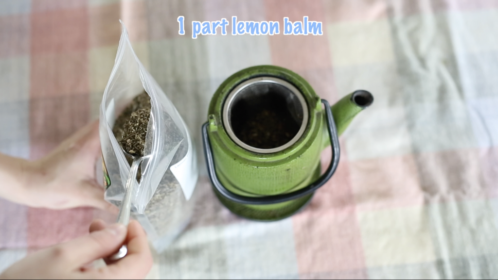scooping lemon balm leaf into tea pot sift