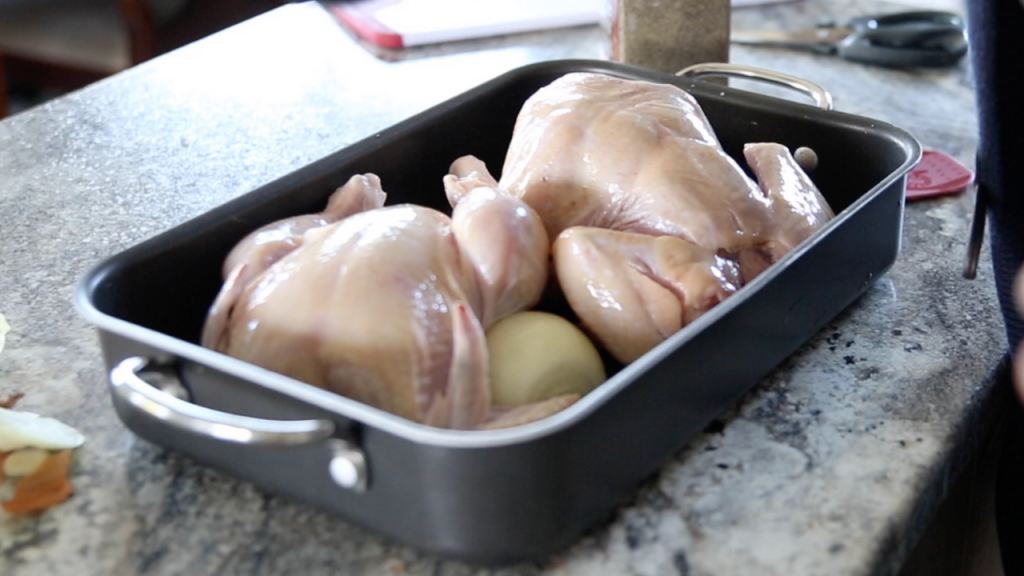 two bare whole chickens in an oven pan