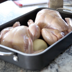 two bare whole chickens in an oven pan
