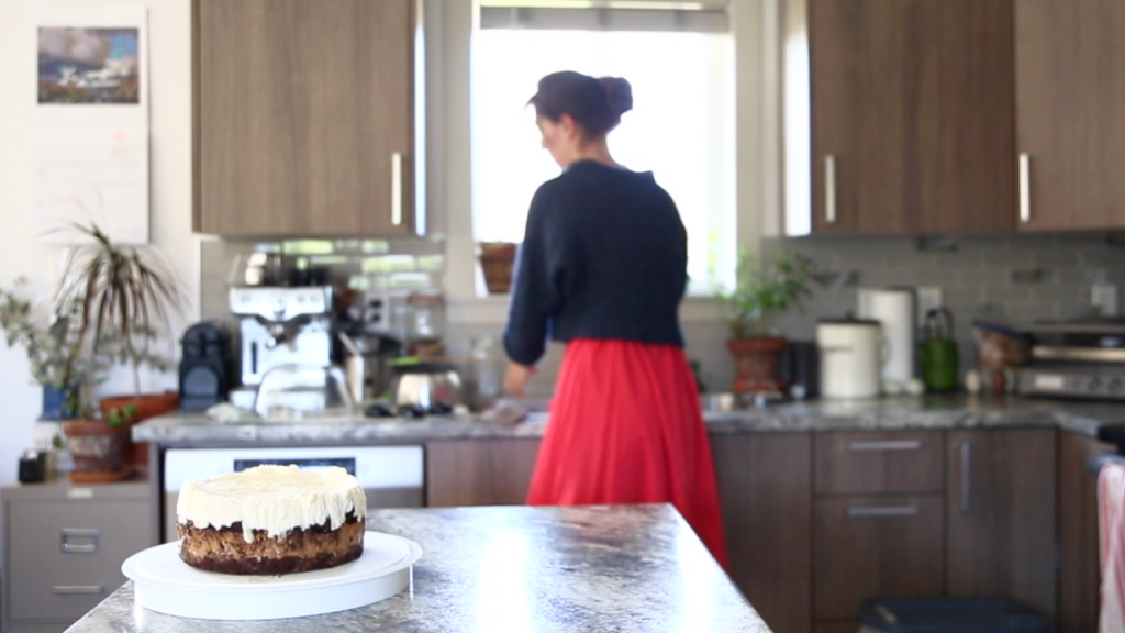 tuxedo cake in counter with woman in background