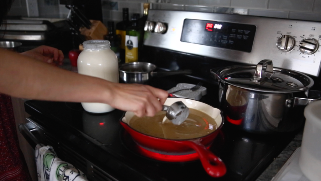 adding heavy cream from a milk jar in with homemade white sauce