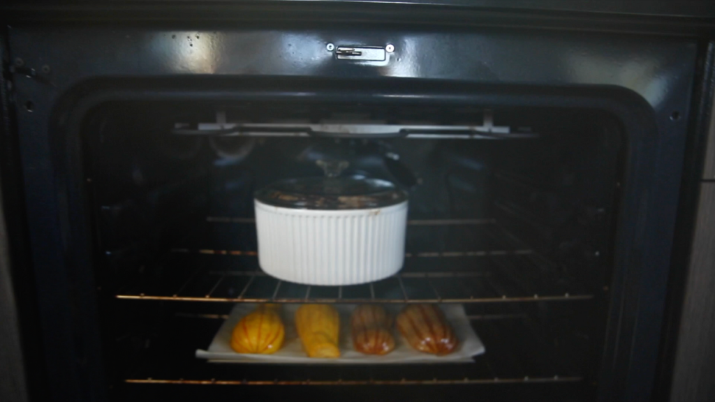 lamb chops cooking in Theo oven in a white oven dish with a lid
