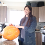 giant pumpkin in kitchen woman standing beside it