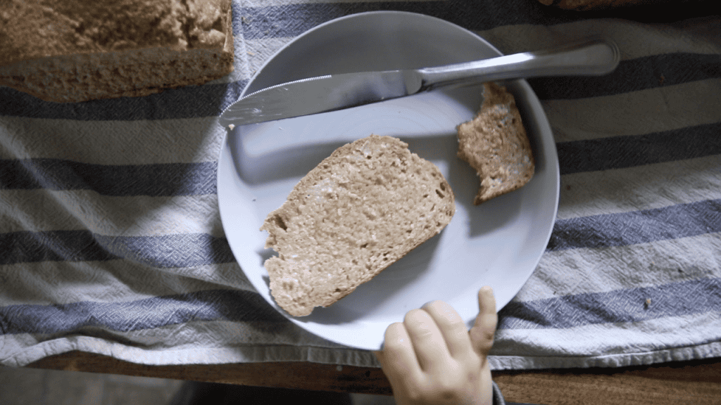 buttered slice of whole wheat sourdough bread in a plate